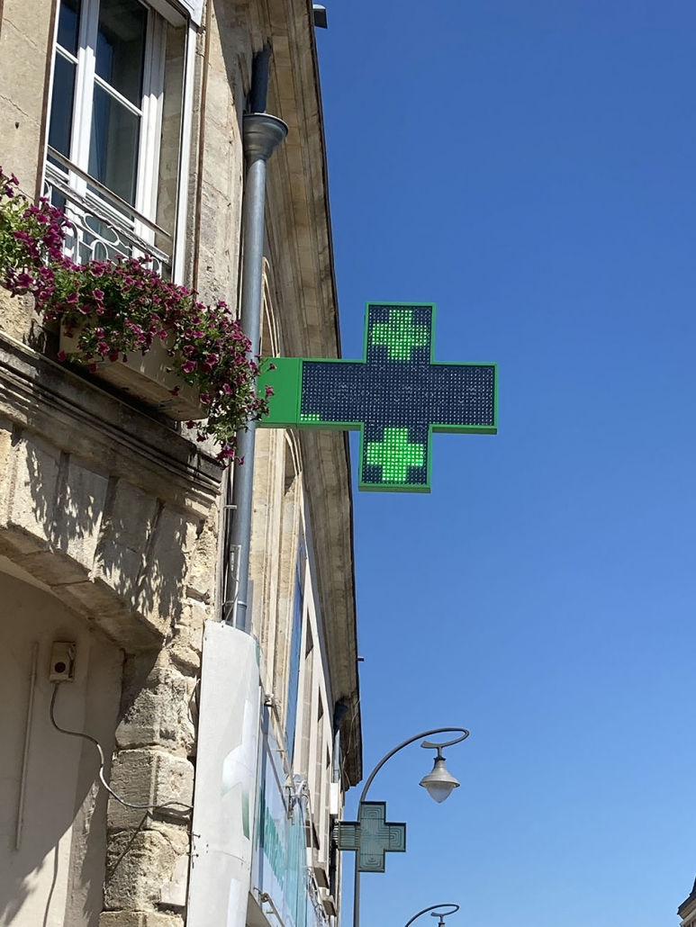 Installation d’une enseigne drapeau de pharmacie lumineuse à Bordeaux par Bordeaux Visuel Impact, spécialiste en signalétique professionnelle.