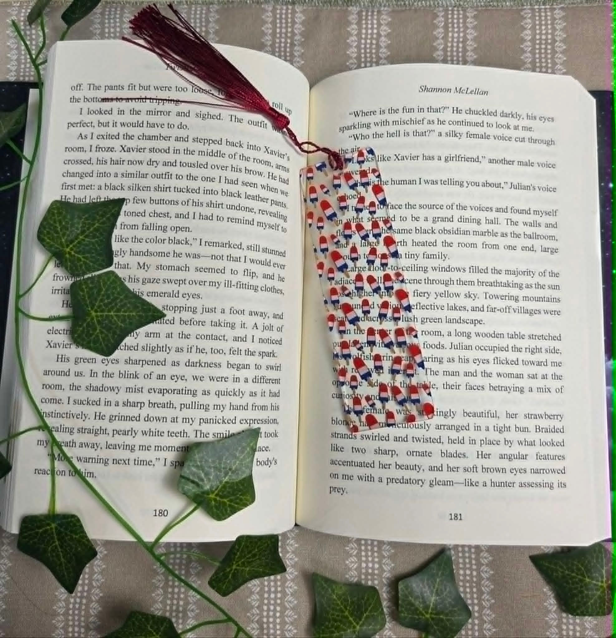 Open book with a red and blue patterned bookmark and tassel.
