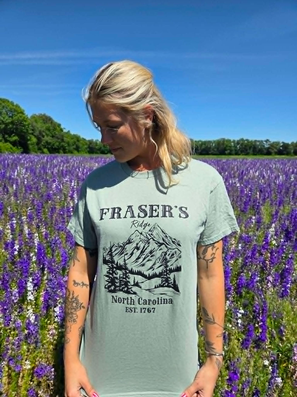 Woman in Fraser's North Carolina mountain graphic t-shirt in field