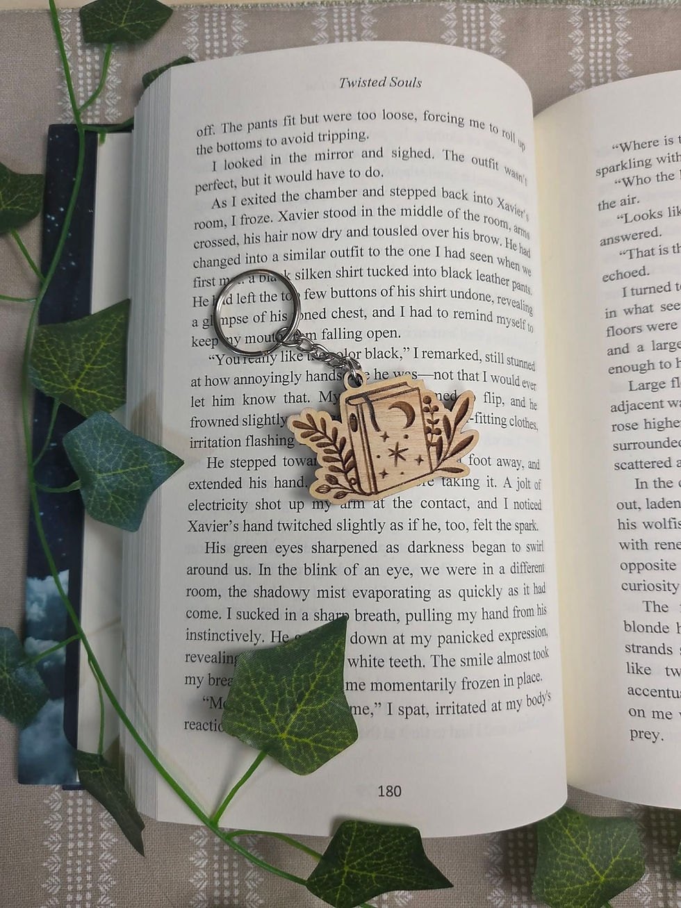 Dragon Wings Book Keychain on an open book with ivy
