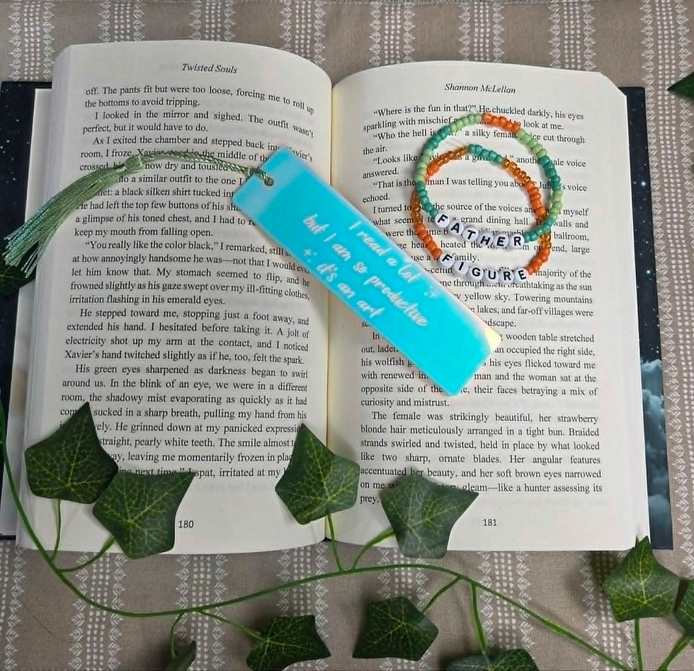 Open book with blue bookmark, READ bracelets, and ivy