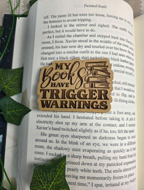 Bookmark on book: 'MY BOOKS HAVE TRIGGER WARNINGS'. Clicking this image takes you to the Magnets category shop page.