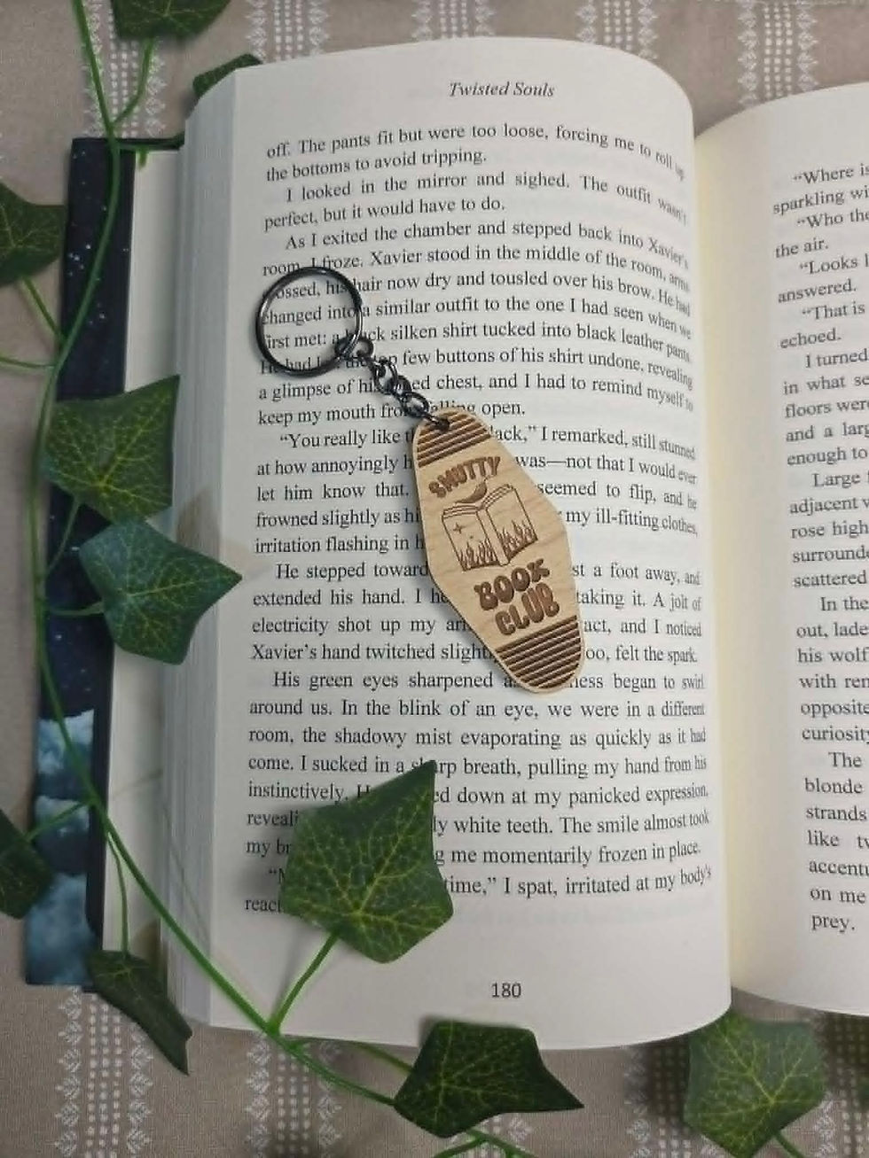 Sweet's Book Club keychain on open book