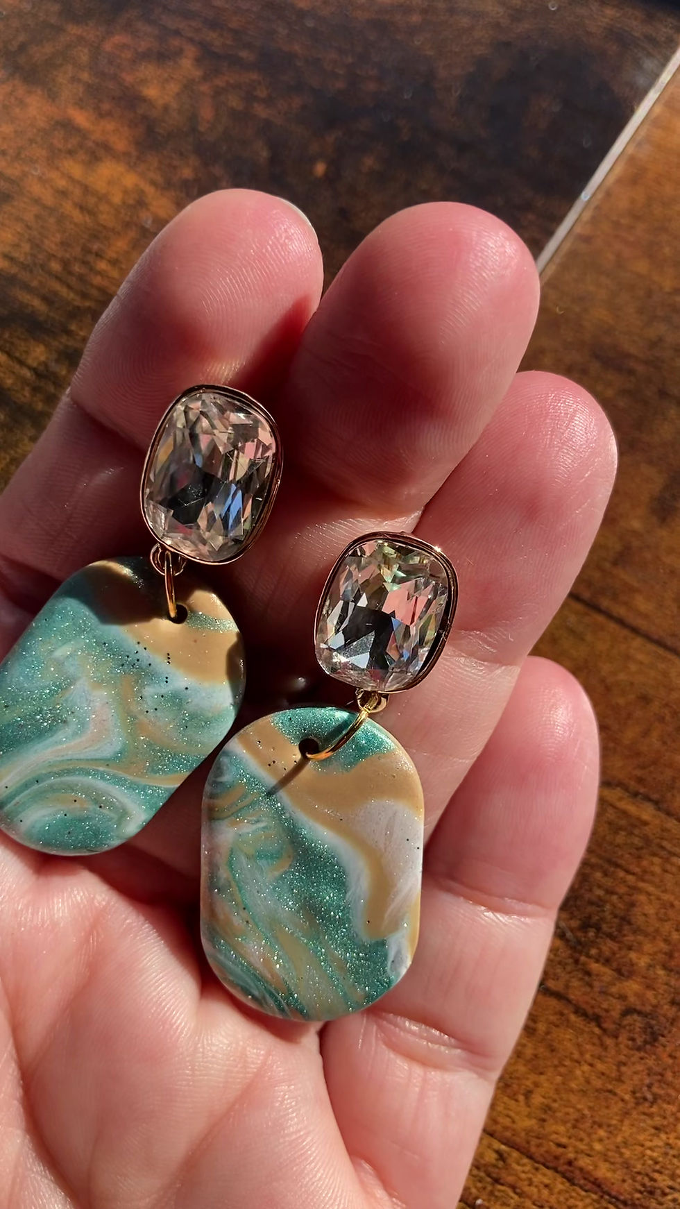 Thumbnail: Shimmery white, brown and teal oval earrings on sparkly white studs