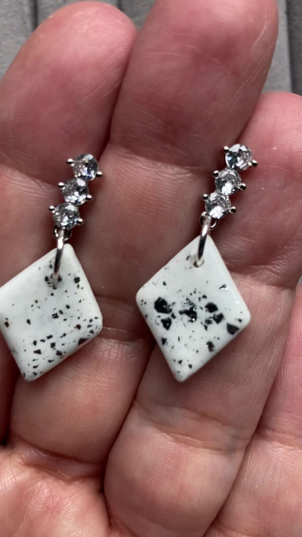 Thumbnail: White rhombus earrings with metallic specs on cubic zirconia studs