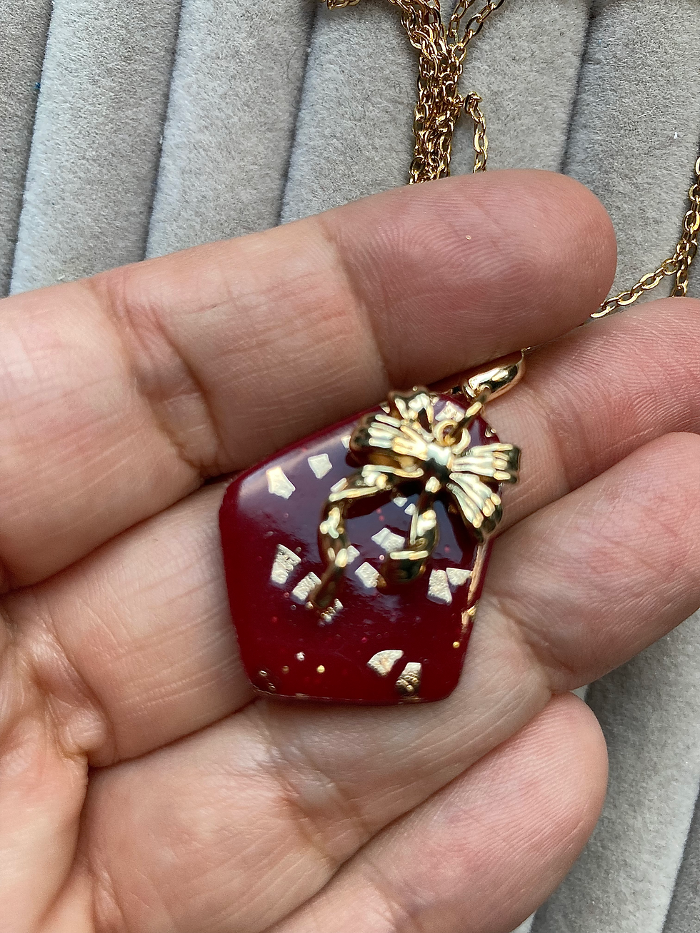 Thumbnail: Red and gold pendant with a bow charm on gold plated chain