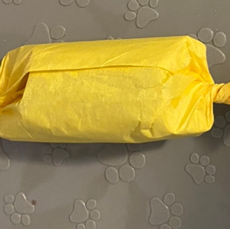 cardboard roll stuffed with dog treats wrapped in tissue paper