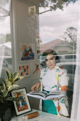 brisbane artist looking at the camera holding her text book