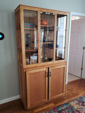 Custom beech China cabinet filled with decorative trinkets.