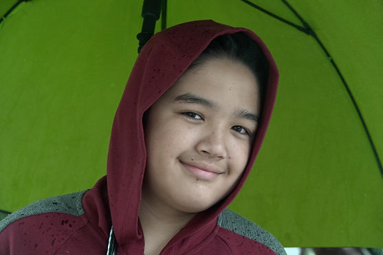 Mahdi smiles under a green umbrella