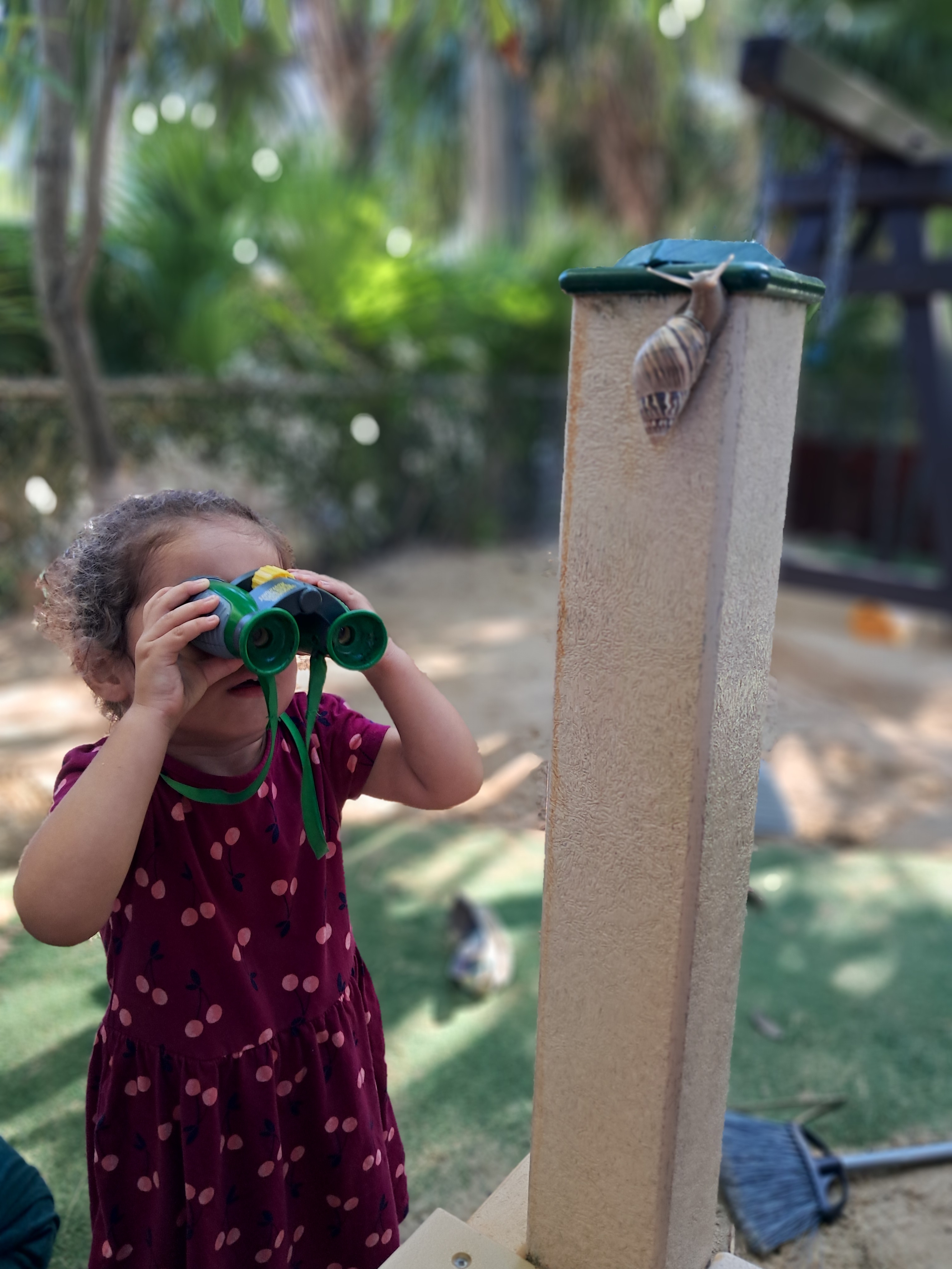 Child exploring outdoors with binoculars