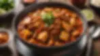 Eye-level view of a bowl of spicy kimchi stew, garnished and ready to serve