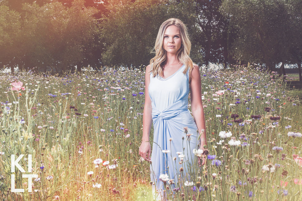 A woman wearing a singlet in a Hawke's Bay garden for a fashion photography shoot for Kilt Clothing