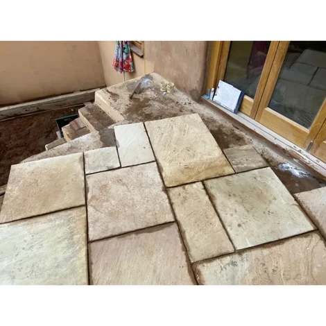 A zoom in photo of a raised concrete platform with indian sandstone slabs placed.