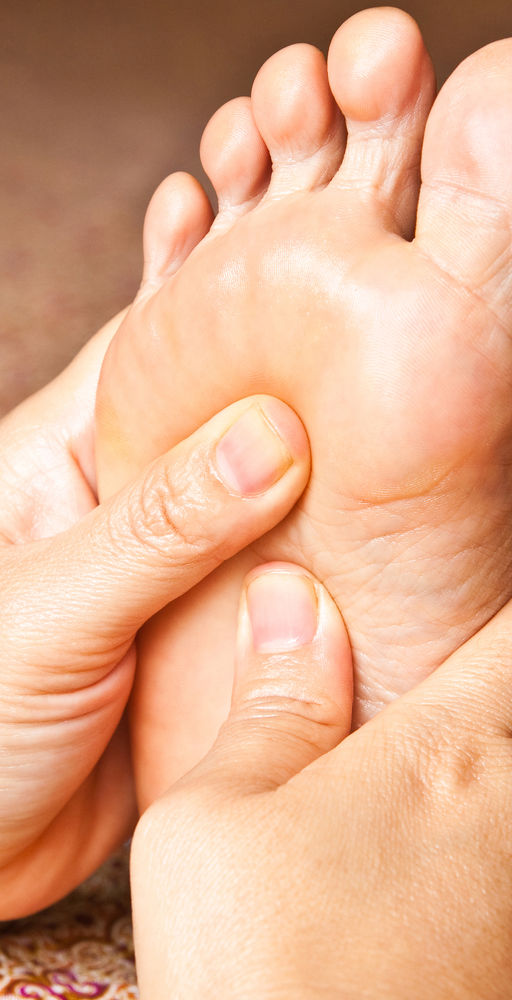 Reflexology on a customer's foot.