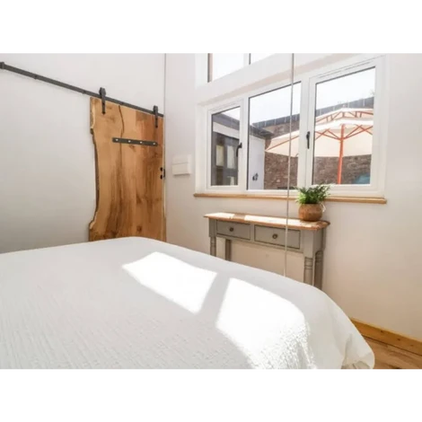 Design and construction of a timber frame hanging bed alongside a solid oak door.