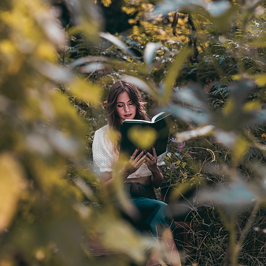 Ali Perkins reading a book in a garden