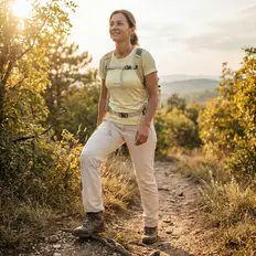 Woman with backpack hiking on a sunny trail