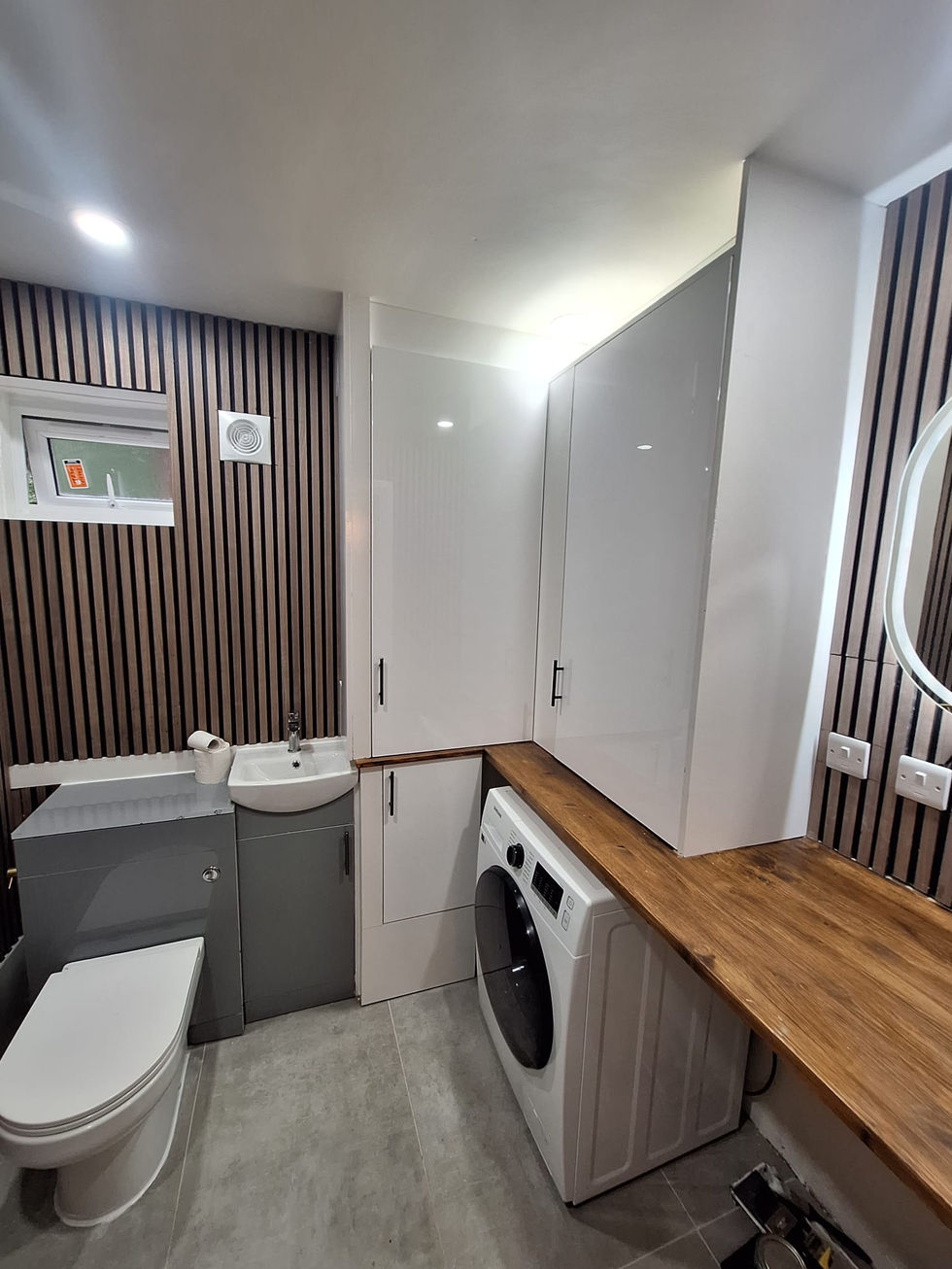 Compact bathroom with vanity unit, round basin and glazed shower enclosure