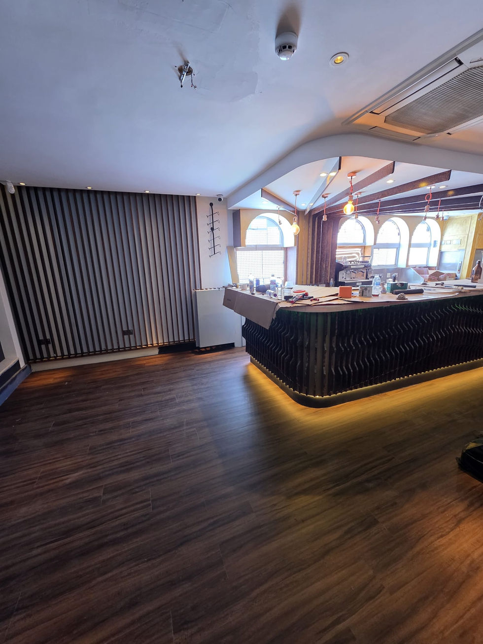 Commercial bar fit out in progress with bespoke curved counter, timber detailing and fitted flooring