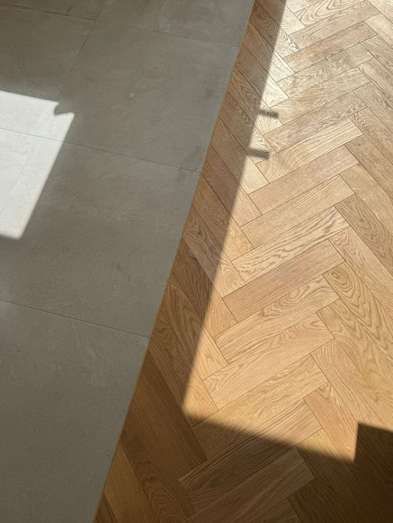 Herringbone wood flooring meeting tiles in Hounslow West property