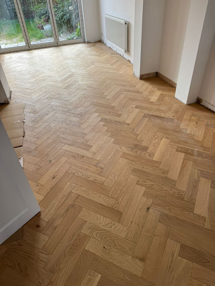 Herringbone flooring fitted around stair base in Hounslow West