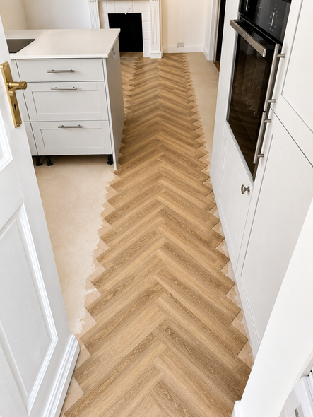 Underfloor heating compatible smoothing compound applied before Amtico herringbone flooring installation
