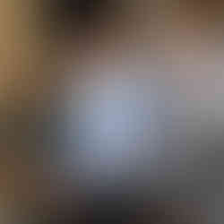 Three attendees smiling at the University of West London Alumni Awards, with event sign visible in the background.