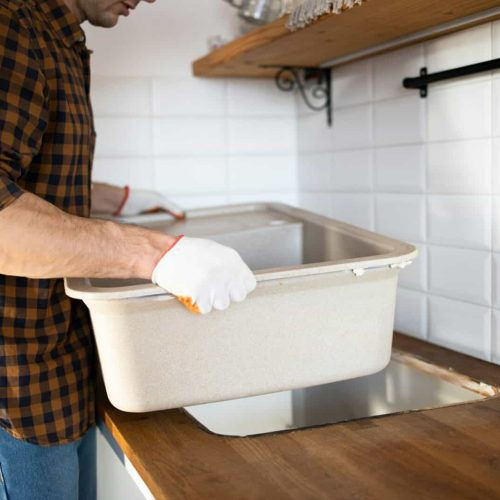 a-man-installs-a-sink-in-the-kitchen-assembly-of-kitchen-furniture--e1718703288499-qqon0dk