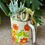 Thumbnail: A gorgeous colourful vintage flour sifter with a variety of colourful succulents