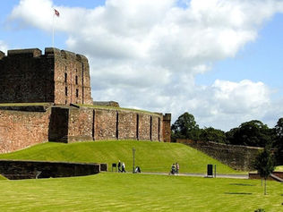 carlisle castle Ancient stone castle on a grassy hill under a blue sky with clouds. People walk nearby, and trees line the background. Calm and historic setting.