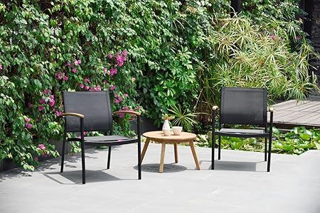 two black metal patio chairs with wood detail on arm beside round wooden side table