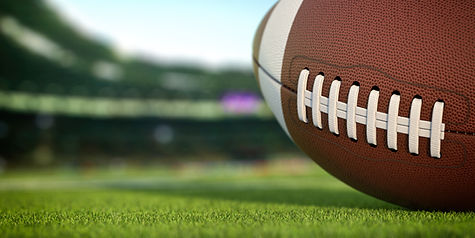american-football-ball-on-grass-of-football-arena-M2THXJQ.jpg