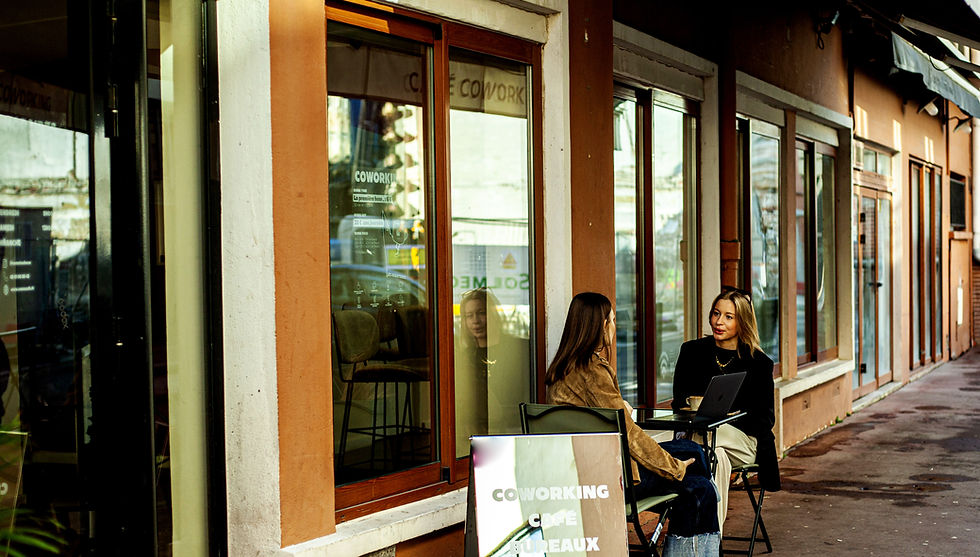 Deux femmes travaillant sur un ordinateur en terrasse devant NOMA Café Coworking à Toulouse, dans un espace extérieur calme et ensoleillé idéal pour travailler en terrasse à Toulouse.