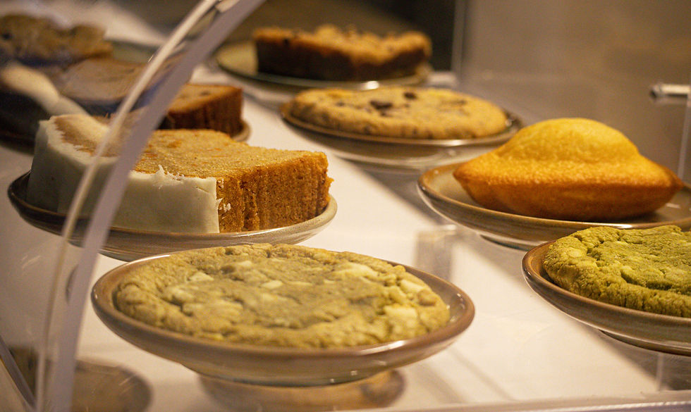 Sélection de pâtisseries maison : cookies matcha, banana cake, carrot cake et madeleines dans un café coworking Toulouse, idéal pour une pause gourmande.