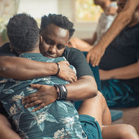 dois homens pretos se abraçando