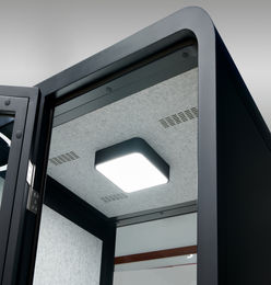Looking up at the interior ceiling and light fixture of the black SoloPod.