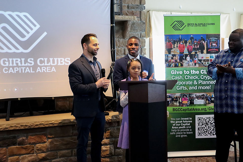 Two men and a girl at podium, BGCCA, giving a speech; CEO Transition.