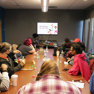Group of people at a workshop with text on screen. BGCCA.