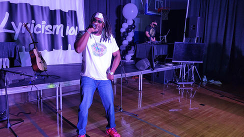 Man with microphone singing on stage with DJ, 