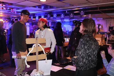 People at a pirate-themed event, skull flags, and event decorations BGCCA.