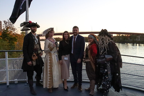 People in pirate costumes posing, 2022 Gala: Pirate Cruise, on a boat deck.