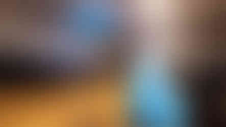 Blue inflatable dinosaur and people gather inside gymnasium for event BGCCA.