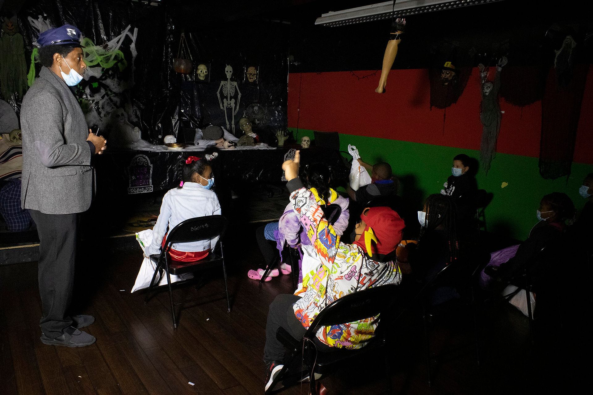 Group of people wearing masks in a dimly lit room BGCCA.