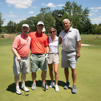 Four golfers pose on green during the 2021 Chip In Fore Youth BGCCA golf tournament.