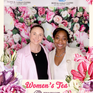 Two women pose, surrounded by flowers, for the Women's Tea BGCCA 2024