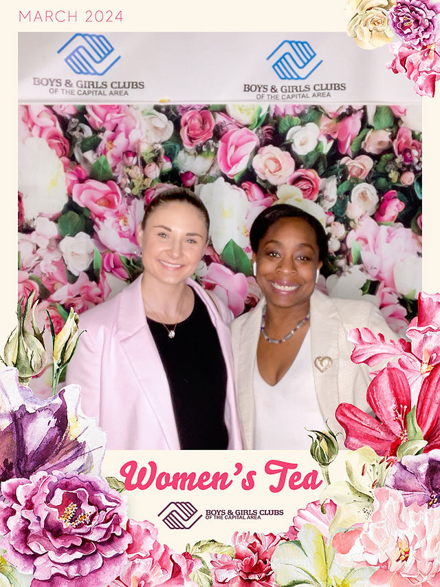 Two women pose, surrounded by flowers, for the Women's Tea BGCCA 2024