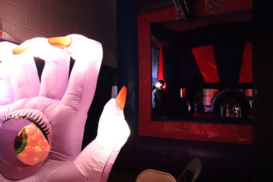 Large inflatable hand with red nails and a dark room BGCCA background.