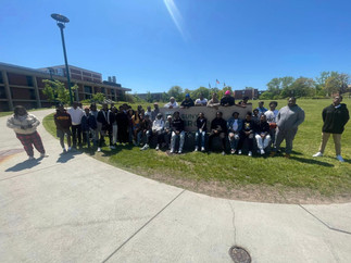 Group of people standing on grassy terrain, sunny day BGCCA