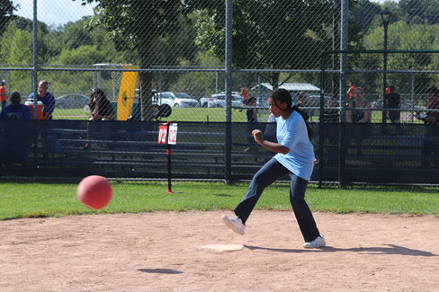 Young girl kicks a red ball during a kickball game at park BGCCA.